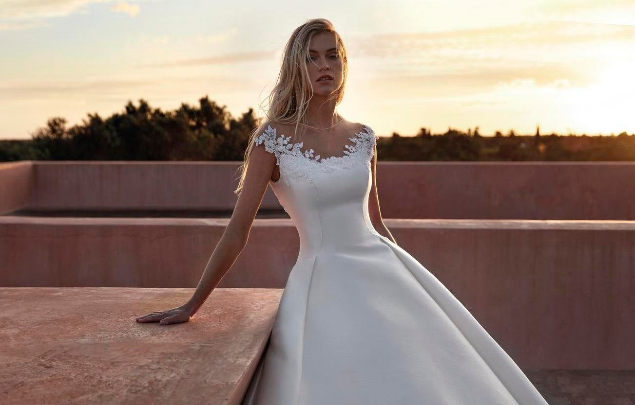 Noiva com um vestido de decote em barco com detalhes rendados