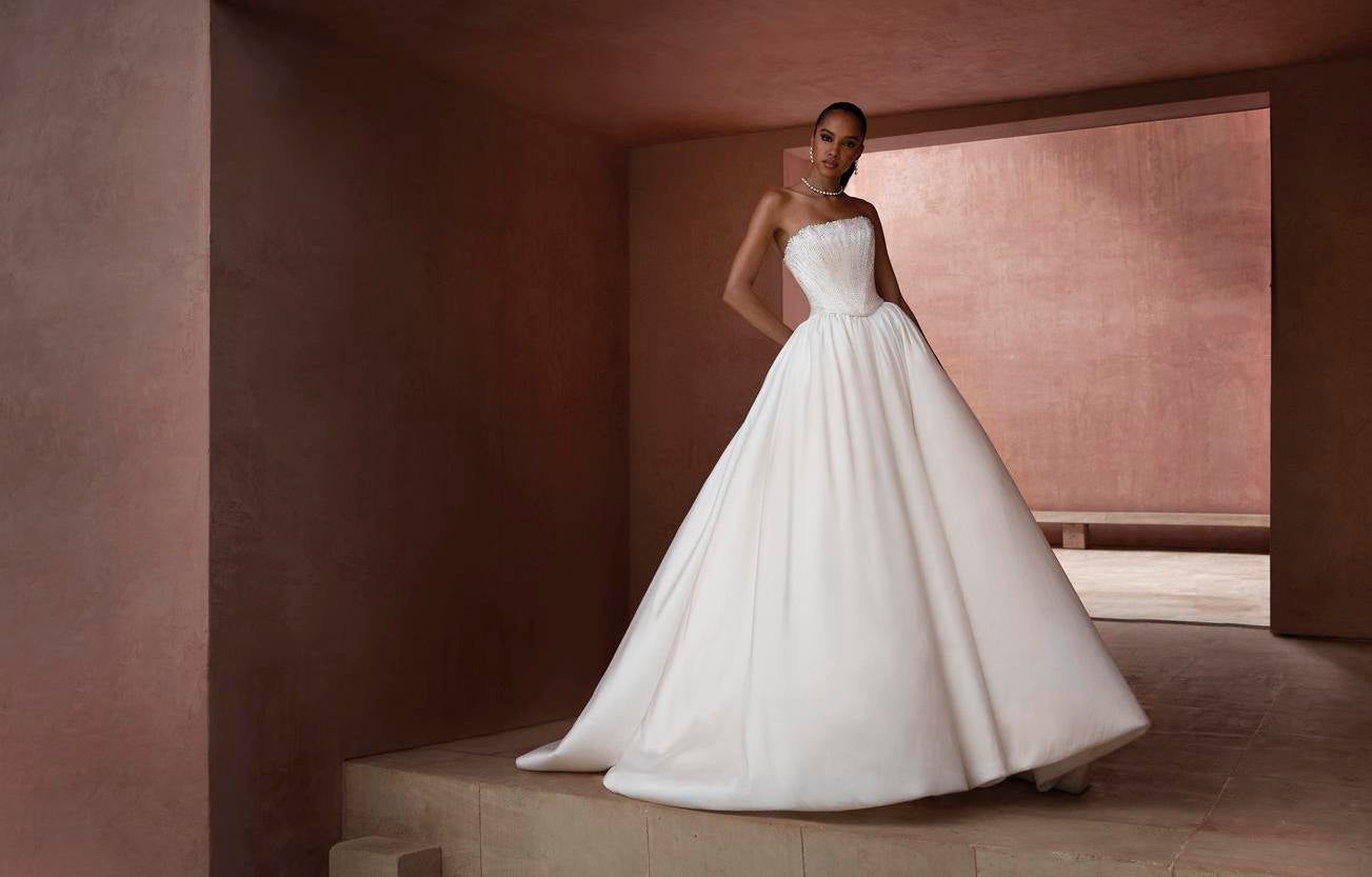 Vestido de nova princesa a com um decote cai cai coordenado com um colar de pérolas e brincos longos