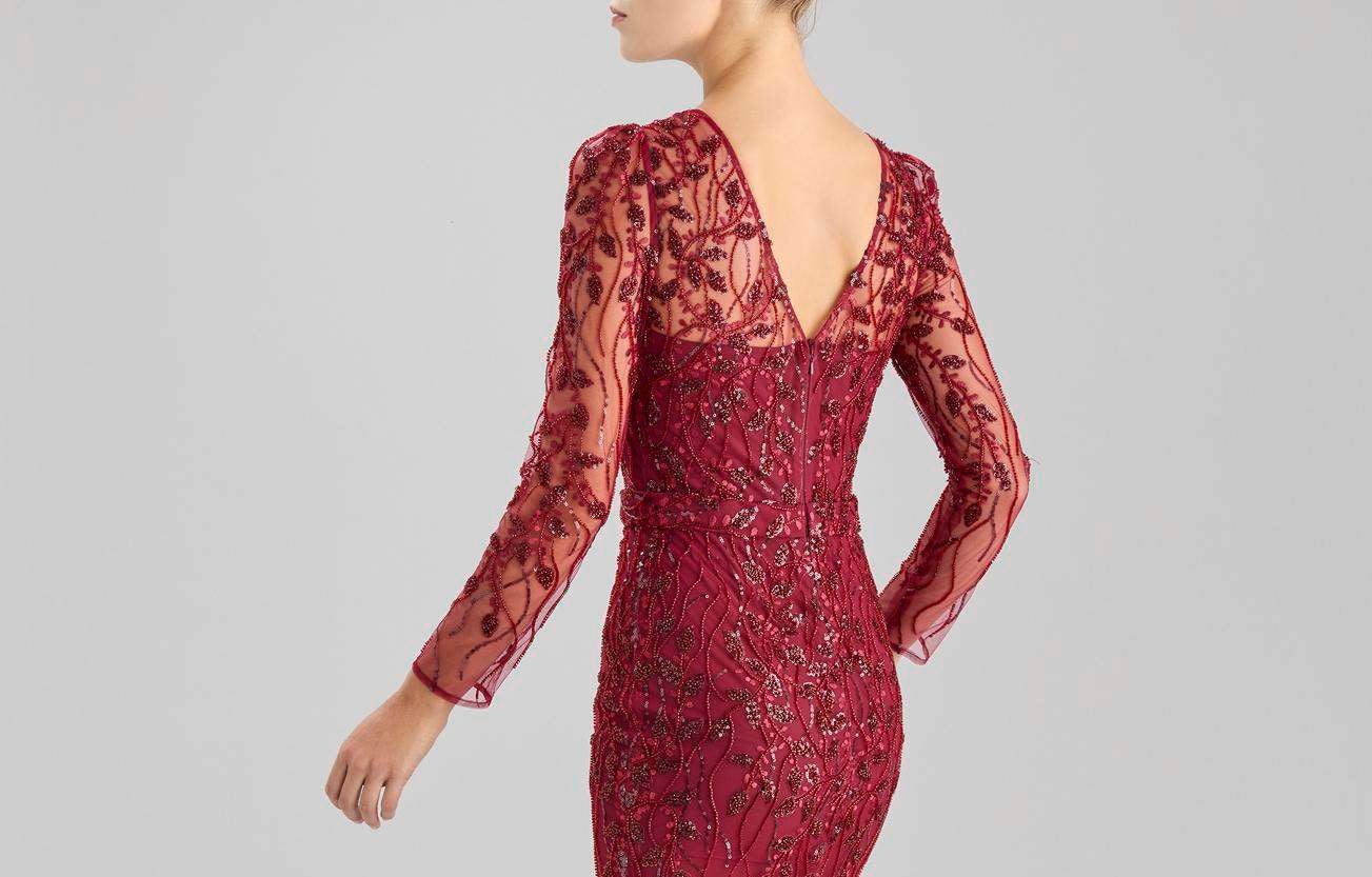 Mujer de espaldas luciendo un vestido de testigo de boda color vino con lentejuelas y transparencias