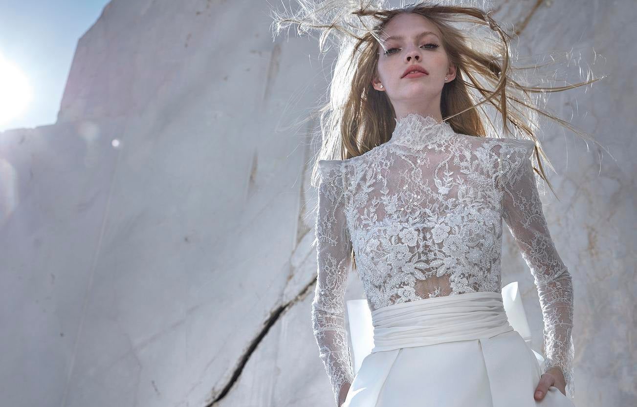 Noiva com cabelo solto e vestido de noiva de renda com mangas compridas e corte A