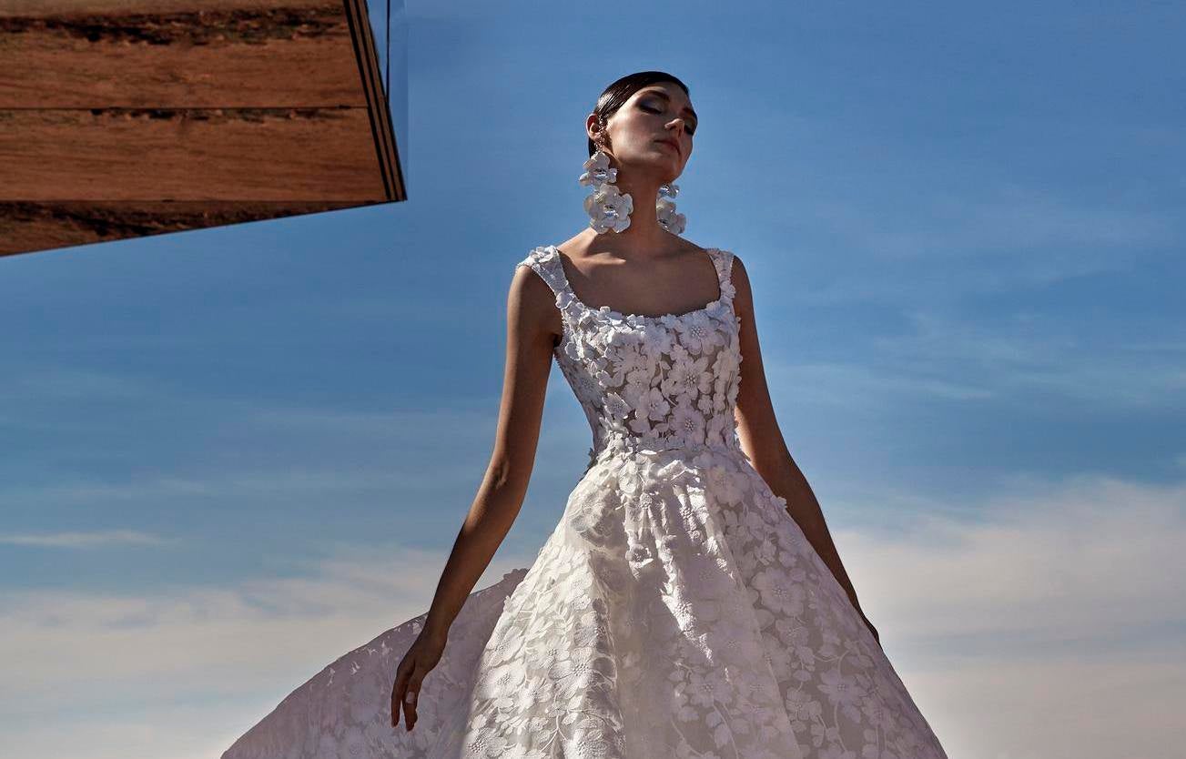 Noiva com vestido de decote barco com bordados florais e brincos statement longos