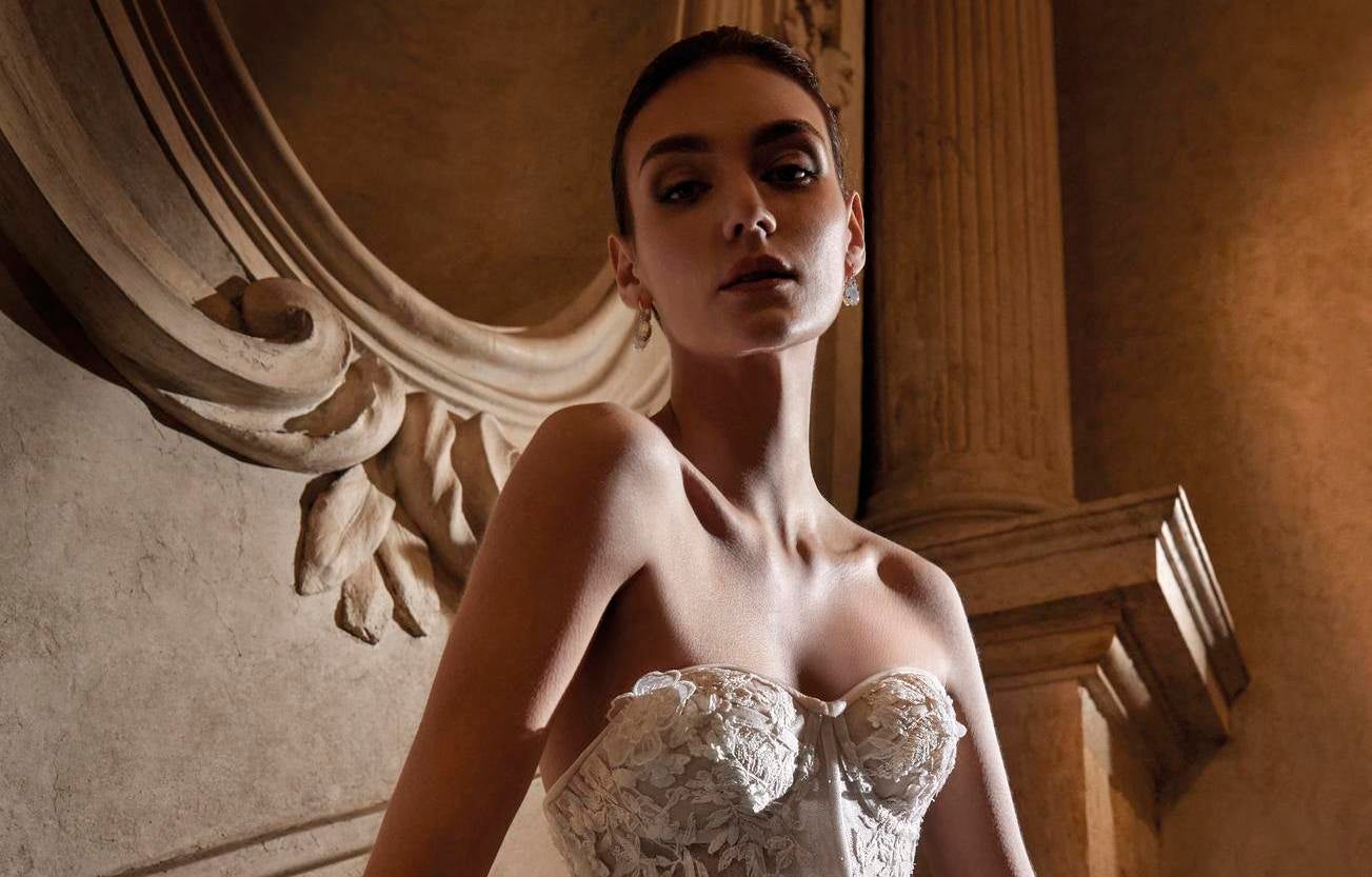 Mujer con el pelo recogido y pendientes de novia con un vestido de novia con escote corazón