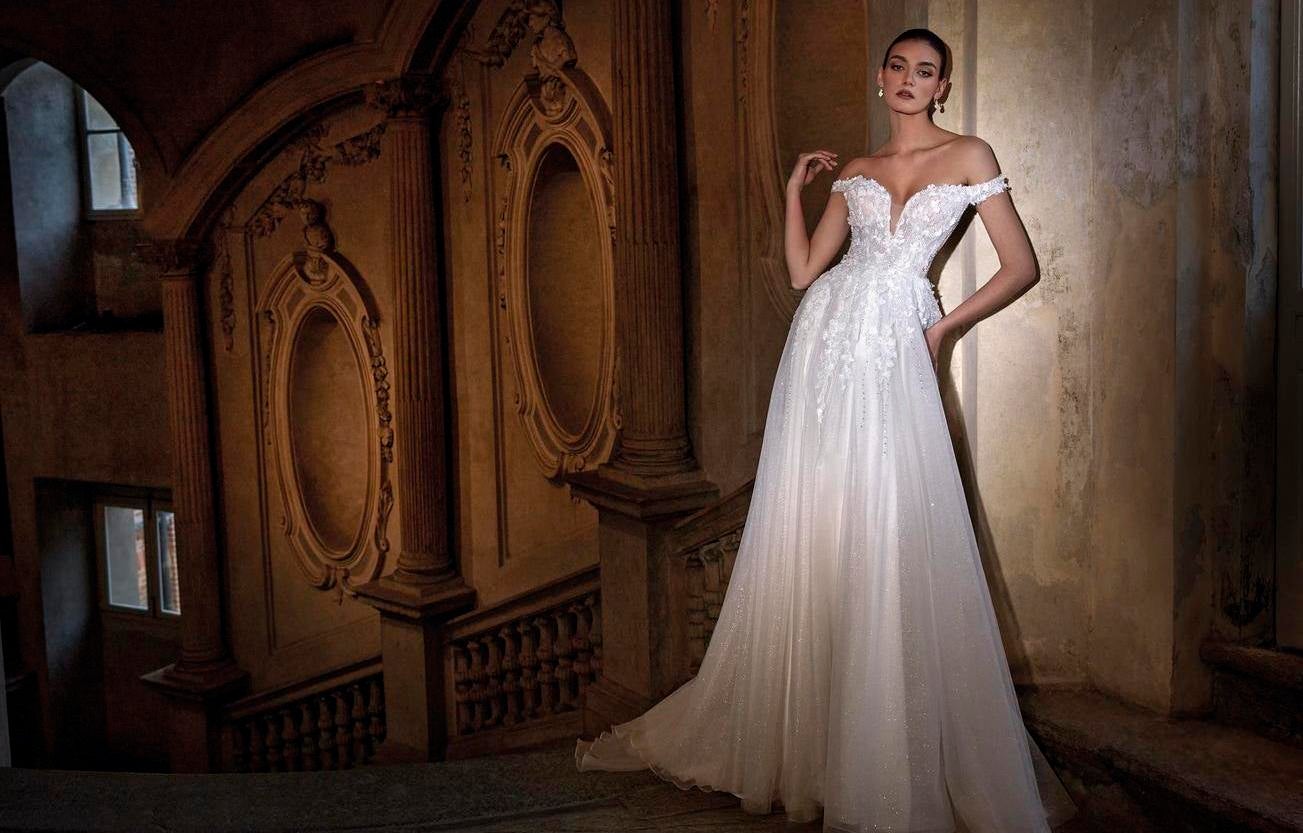 Noiva a usar um vestido de linha A com detalhes bordados na zona do busto e um decote cai cai