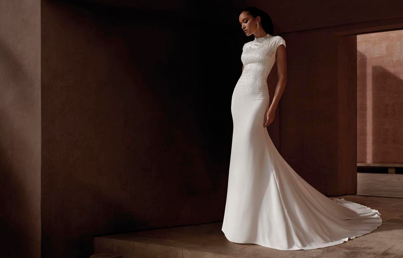 Panna młoda w długiej skromnej sukni ślubnej z zabudowanym dekoltem i krótkim rękawem