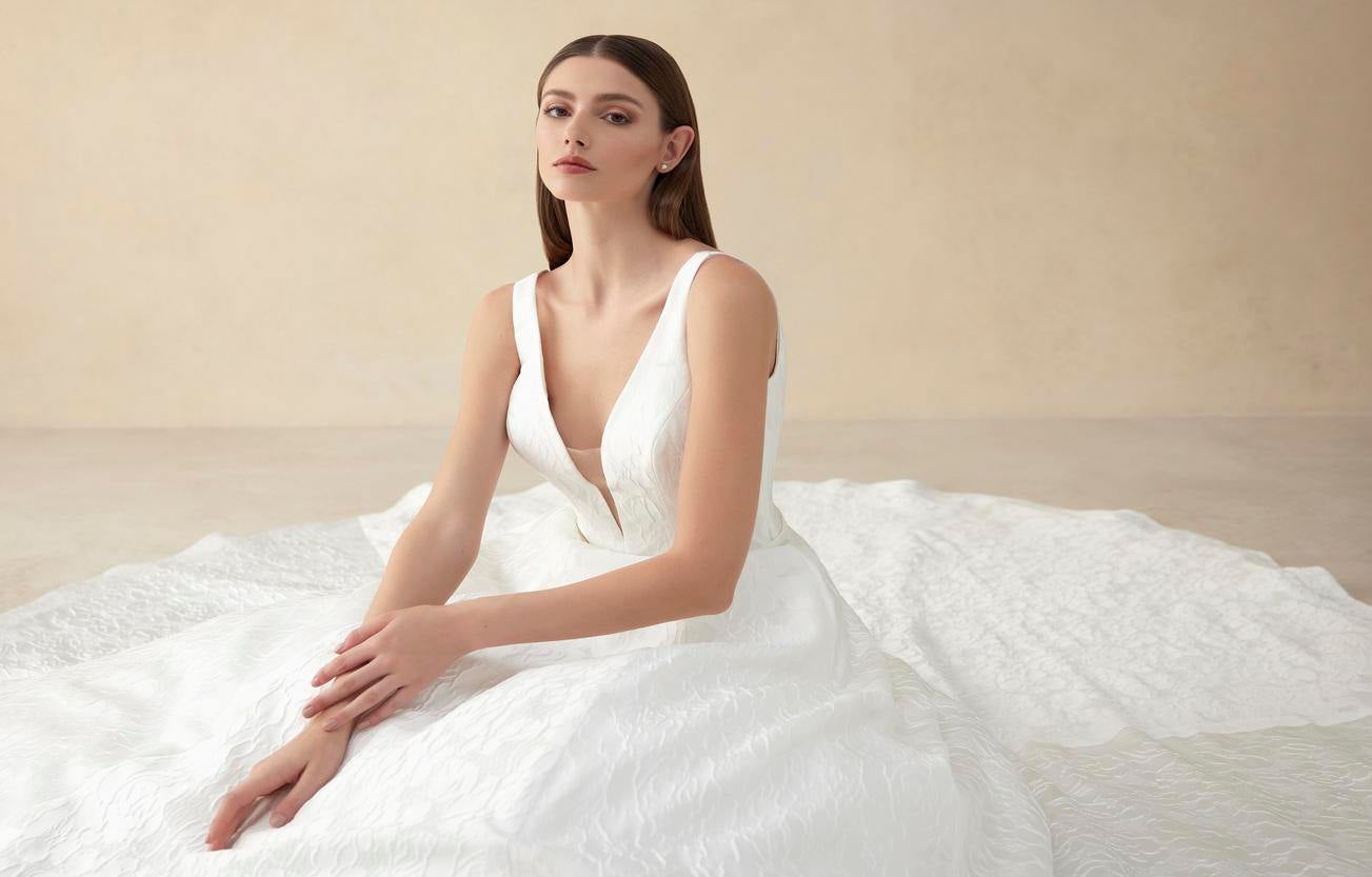 Une mariée aux cheveux longs avec une coupe lisse, une raie au milieu et le reste des cheveux tombant derrière les oreilles.