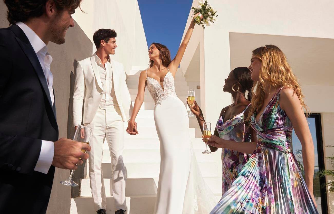 Państwo młodzi wraz z gośćmi tuż po zakończeniu ceremonii zaślubin panna młoda unosi bukiet do góry