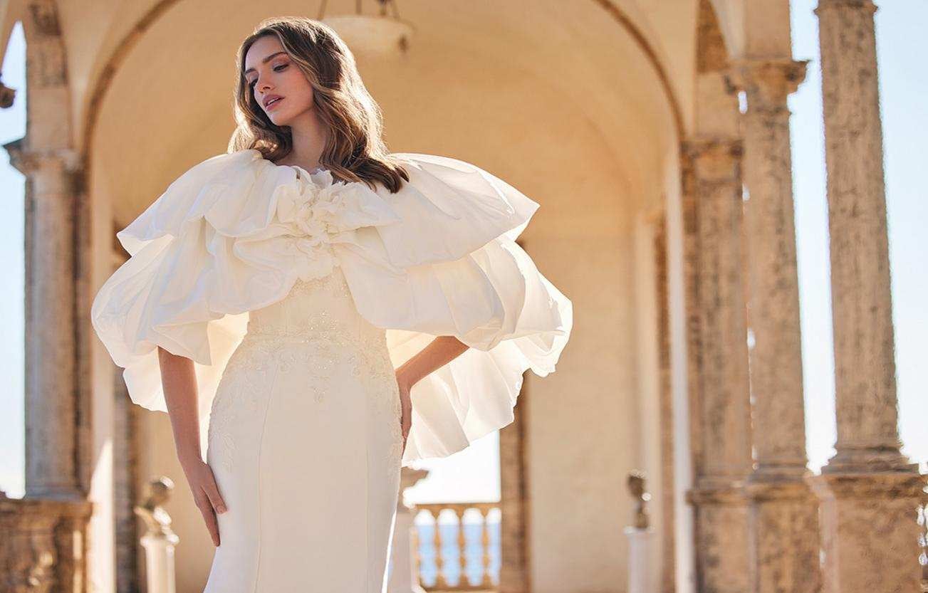 Une ravissante mariée dans une robe de mariée droite perlée dotée de manches amovibles blanches.