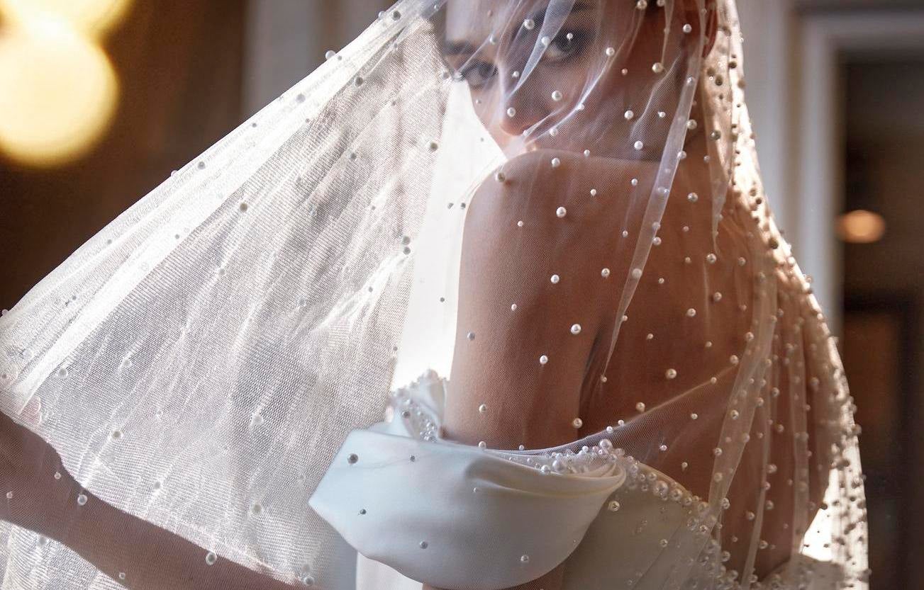 Noiva com véu e vestido de noiva com pérola, mangas balão e costas descobertas