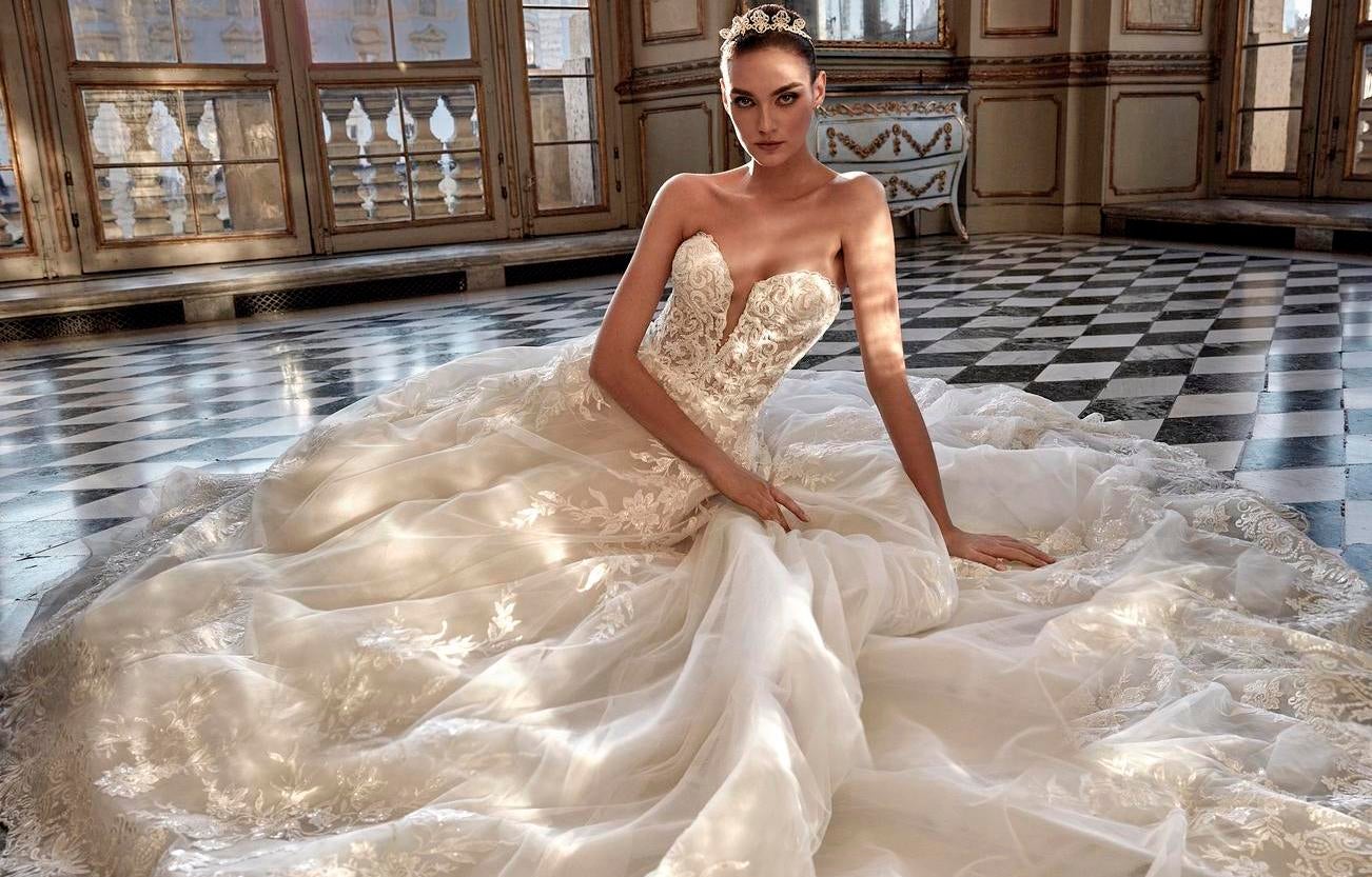 Mujer sentada en el suelo con un vestido de novia blanco estilo princesa