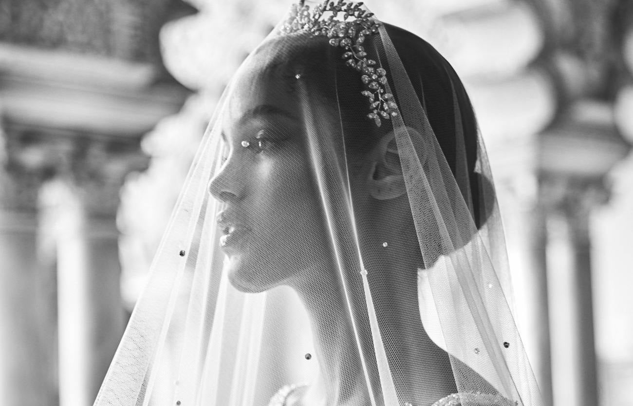 Woman wearing a wedding veil with beaded detailing and a bridal crown