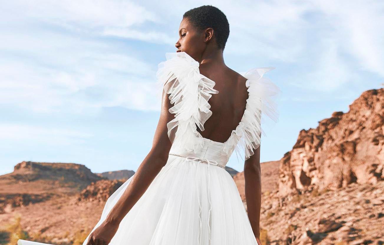 Mujer con look de boda ibicenca al aire libre mientras mira hacia un lado