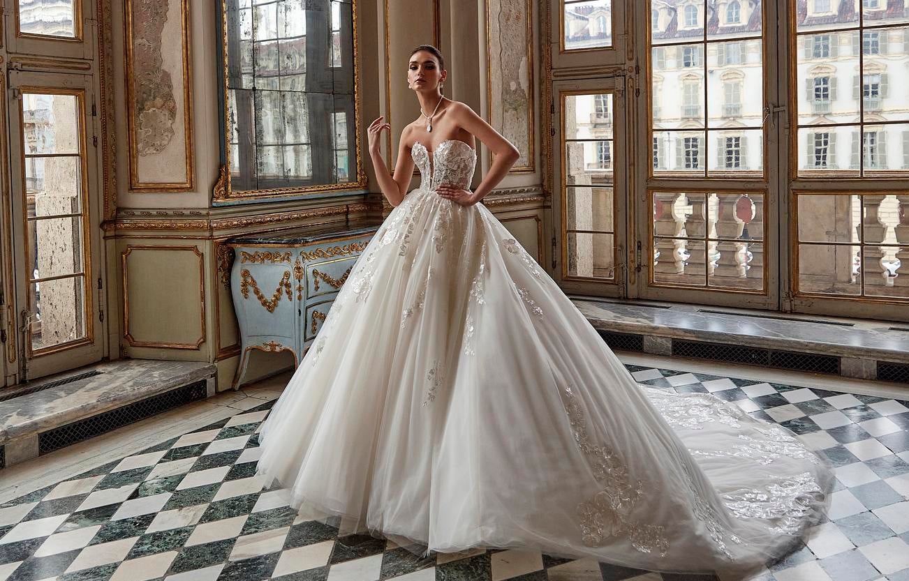 Κομψή γυναίκα με στράπλες νυφικό και εντυπωσιακά κοσμήματα