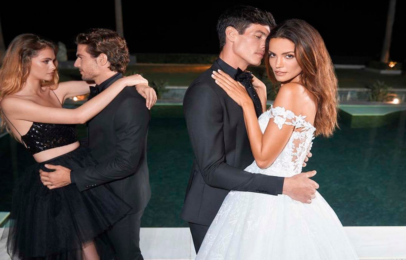 Un couple de mariés enlacés dans leurs luxueuses tenues de mariage, célébrant leur amour avec passion et élégance