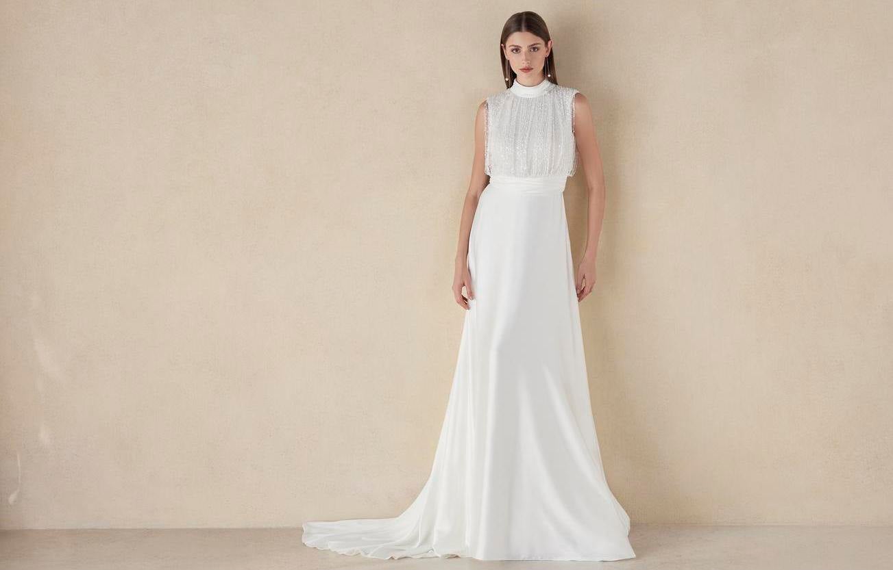 Blond kobieta o rozpuszczonych prostych włosach prezentująca długą suknię ślubną bez rękawów ze stójką