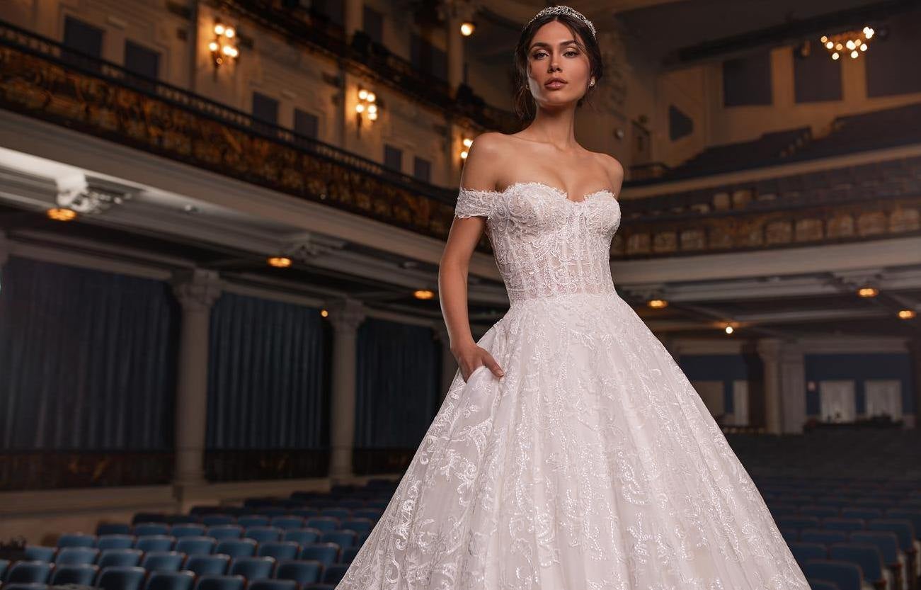 Panna młoda na tle sali teatru w sukni ślubnej oraz z ciemnymi włosami upiętymi w kok oraz delikatnym diademem