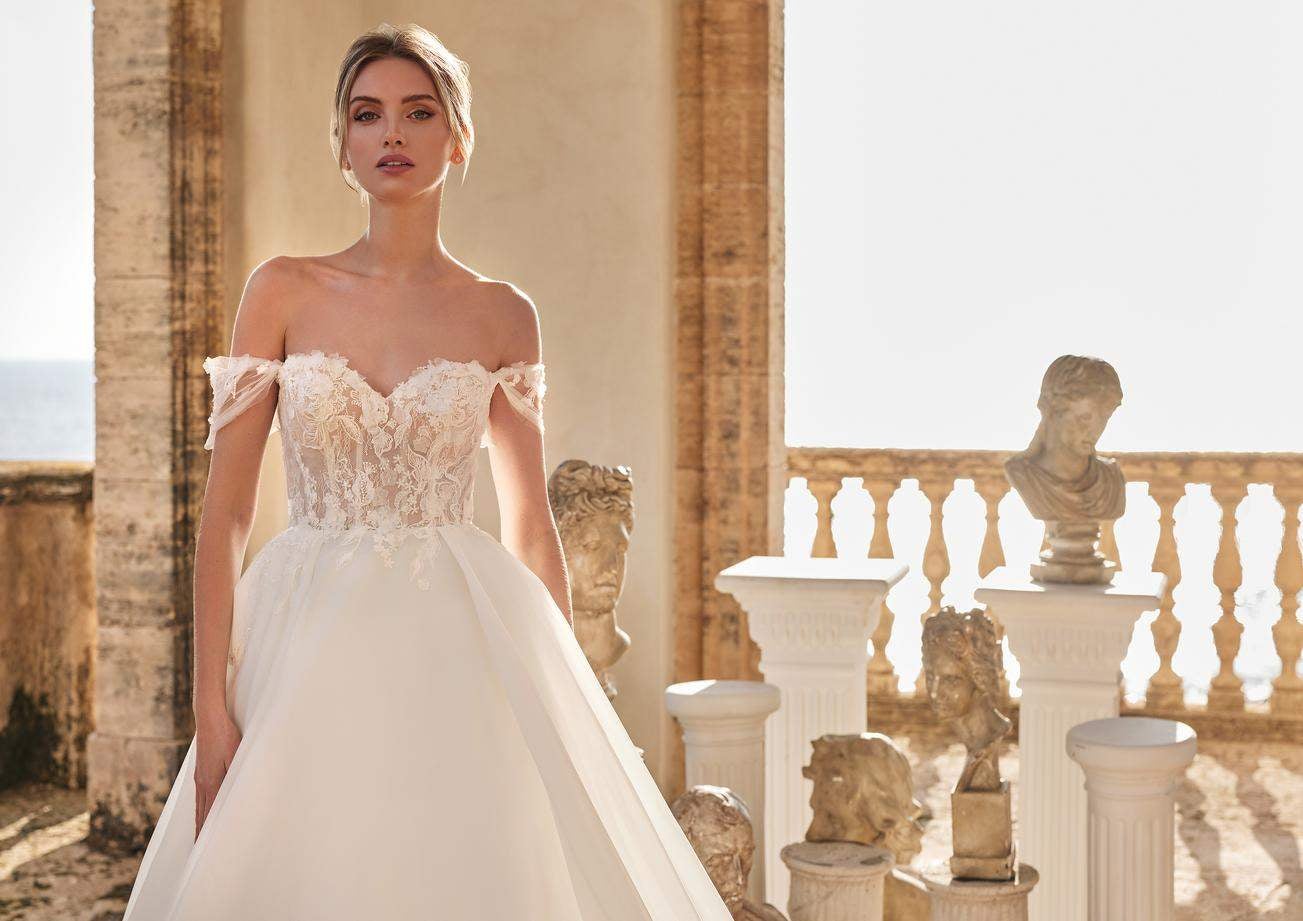 Une ravissante mariée, vêtue d'une robe de mariée bustier style romantique ornée de dentelle et d'une jupe volumineuse