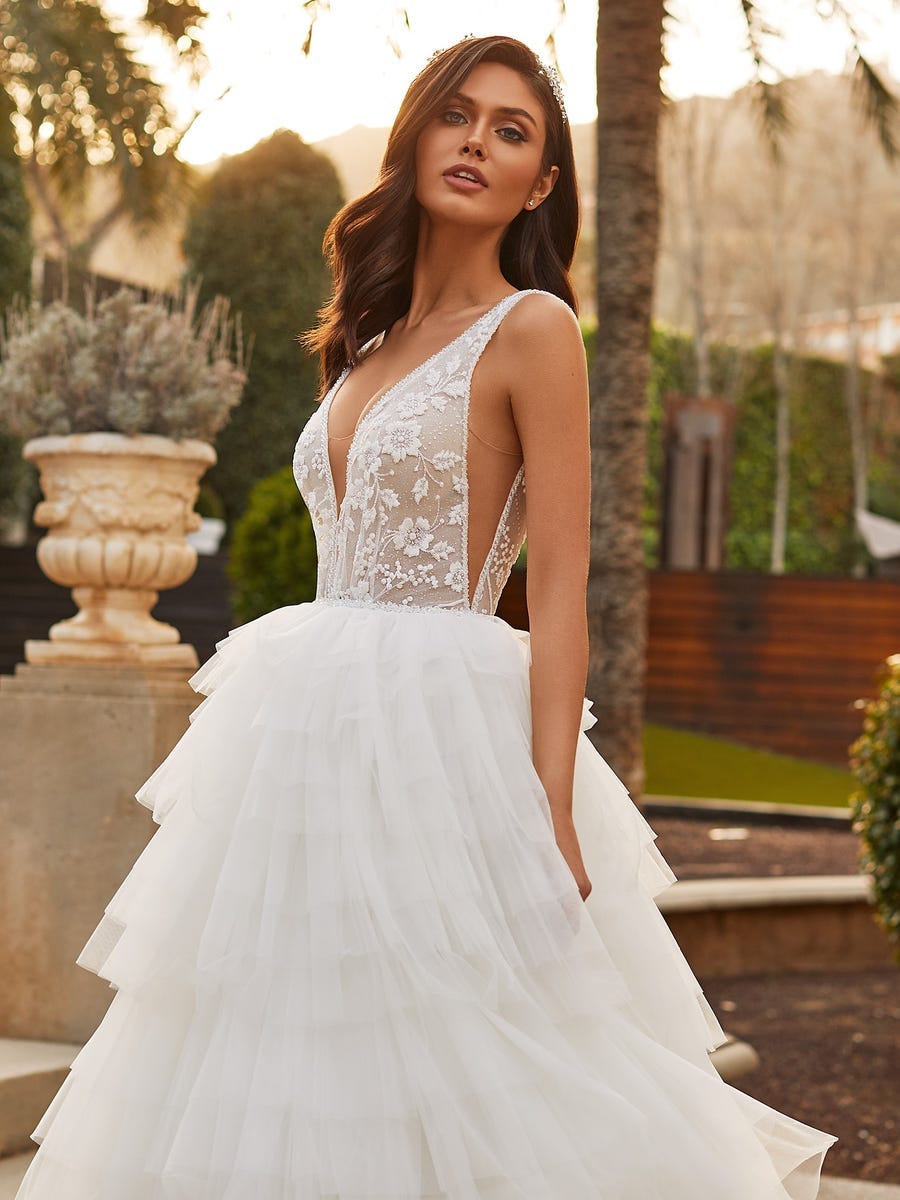 Vestido de novia con escote de encaje Mujer al aire libre luciendo un vestido de novia con escote de encaje y el pelo suelto con una diadema.