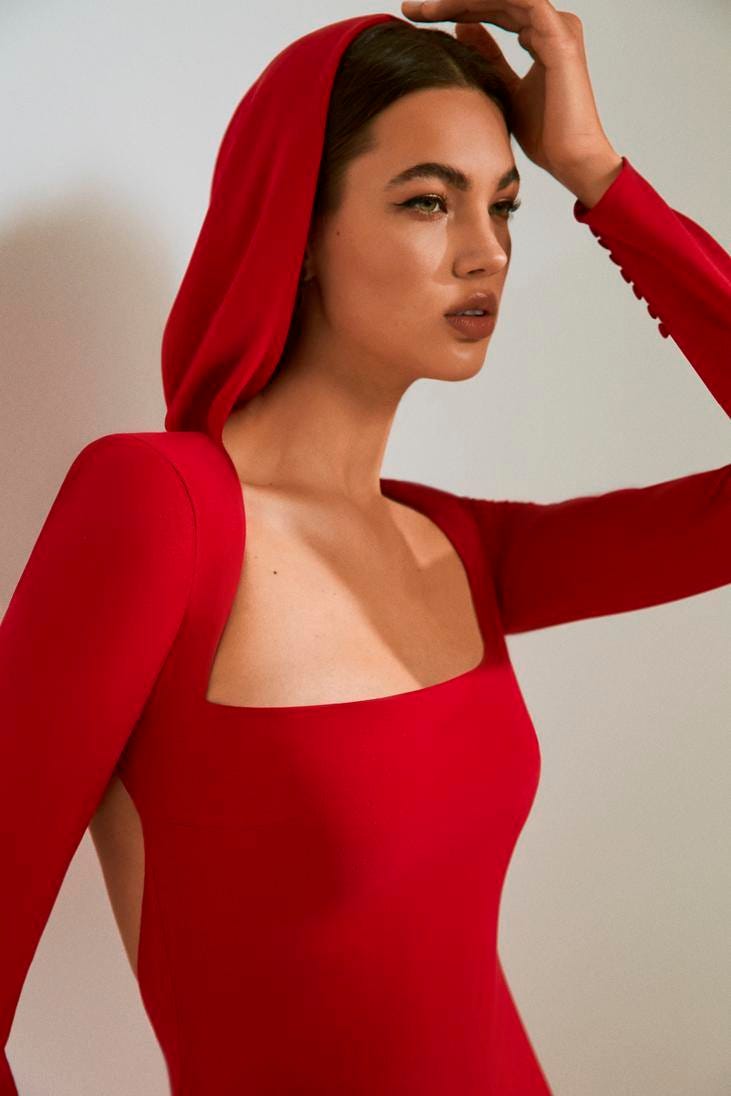 Vestido vermelho com capuz Mulher a usar um vestido comprido vermelho com capuz e um decote quadrado
