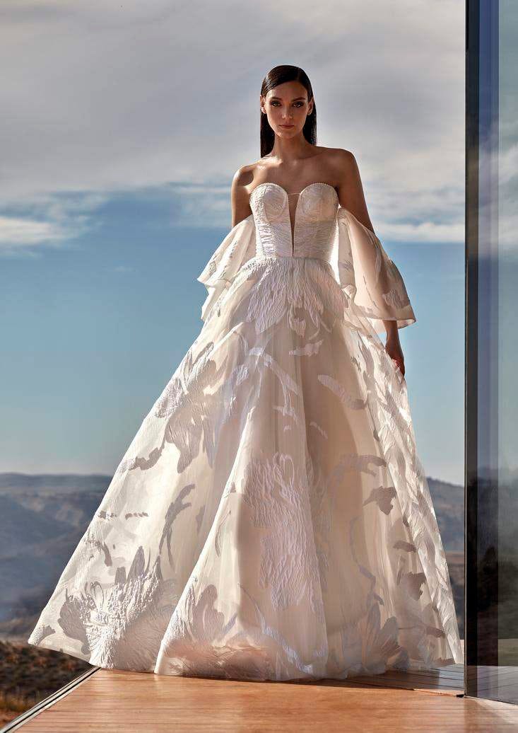 Robe de mariée princesse bustier style moderne Une mariée dans une robe de mariée princesse moderne, bustier, dotée de manches évasées délicates et d'une jupe volumineuse