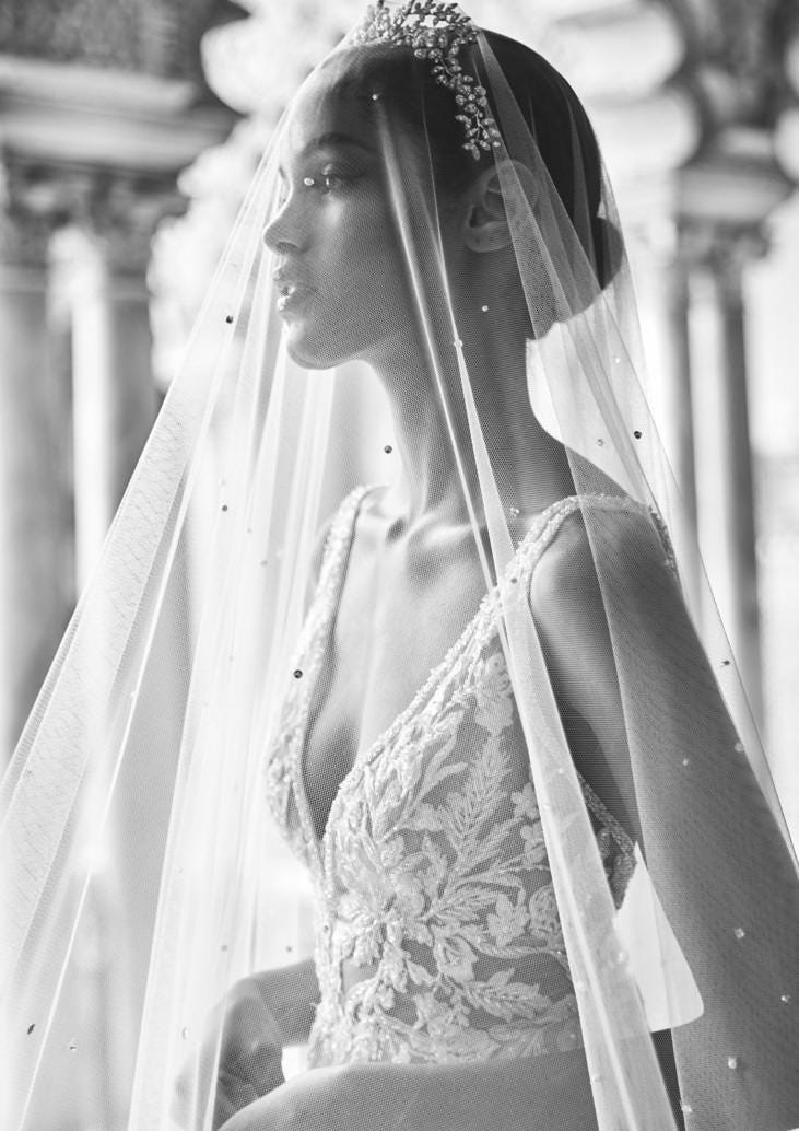 Mujer vestida de novia con un velo dando sus votos matrimoniales