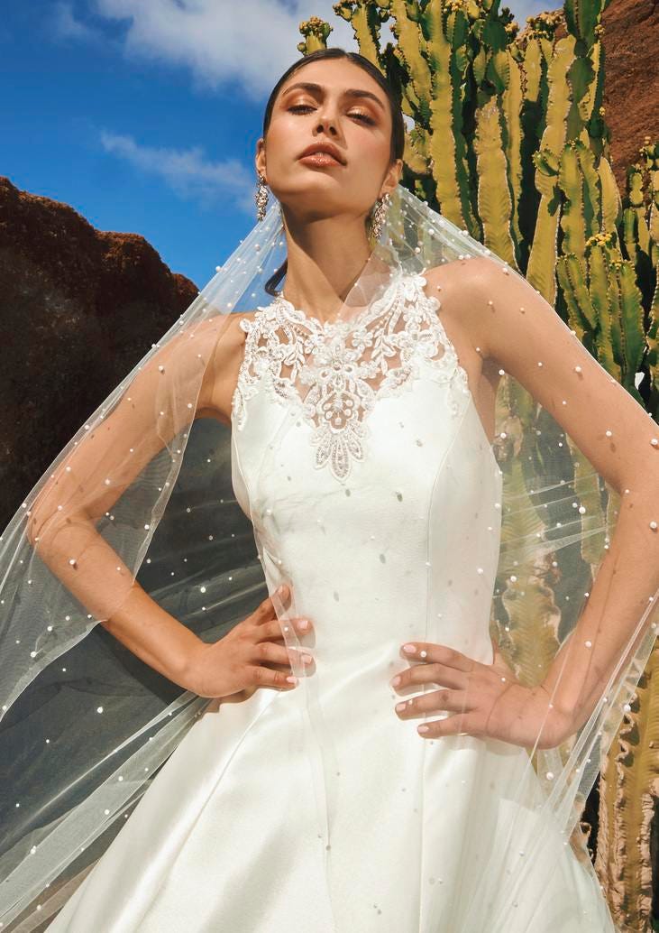 Mujer luciendo un velo de novia largo con perlas y transparencias 