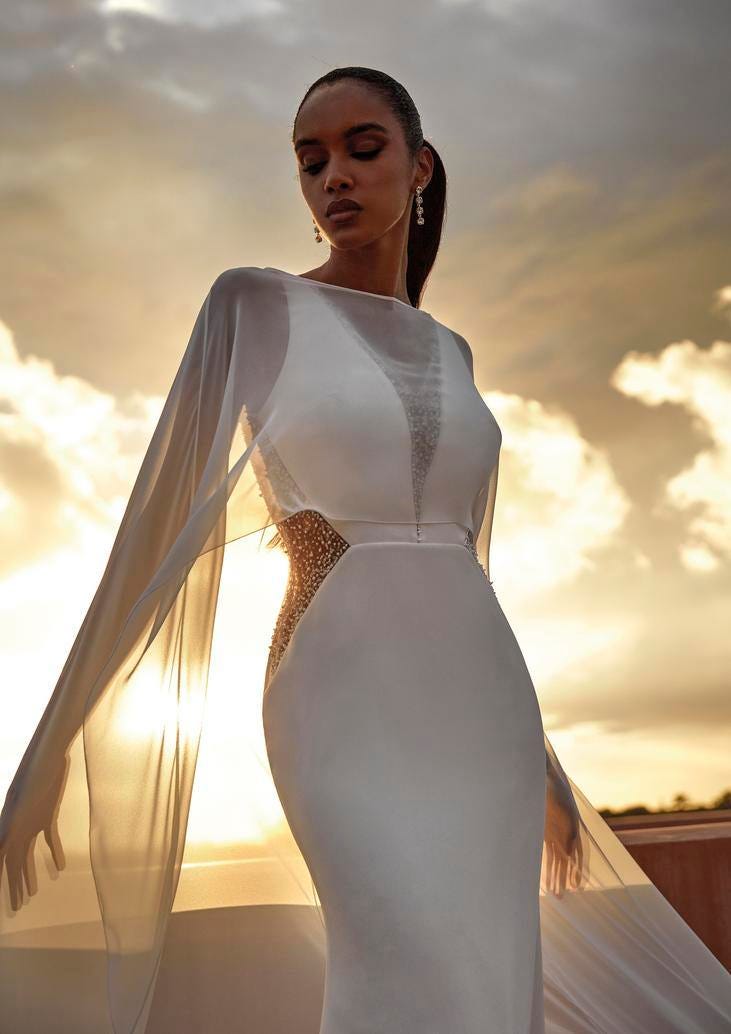 Noiva com um vestido longo liso com transparências e uns brincos longos