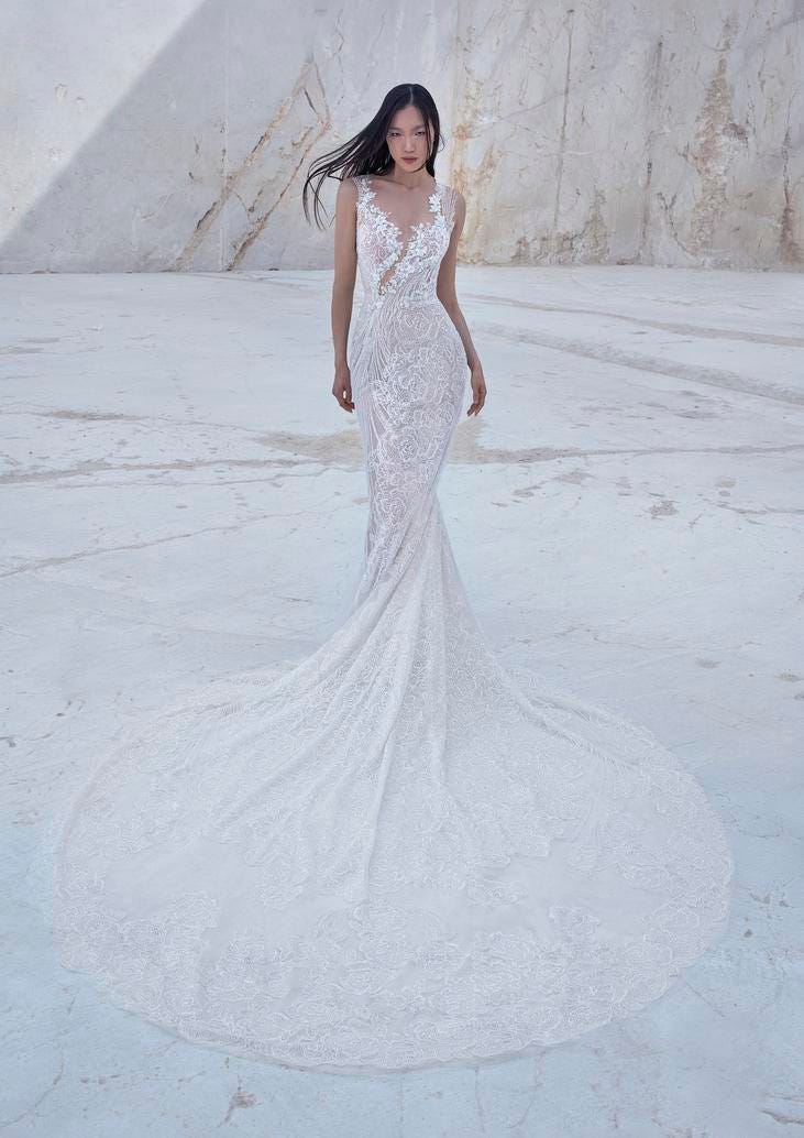 Noiva com vestido longo corte sereia, decote ilusão em V, rendado tem penteado de cabelos soltos ao vento