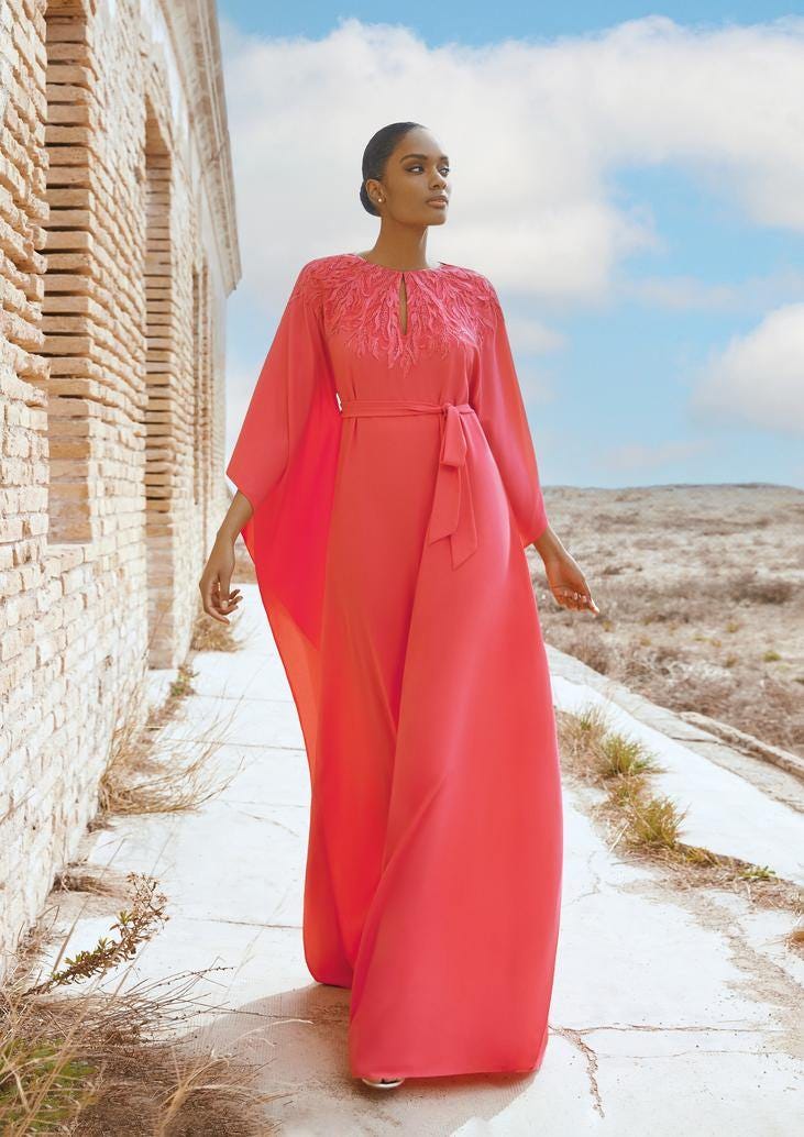 Modella che indossa un lungo abito da cerimonia elegante per partecipare a un matrimonio