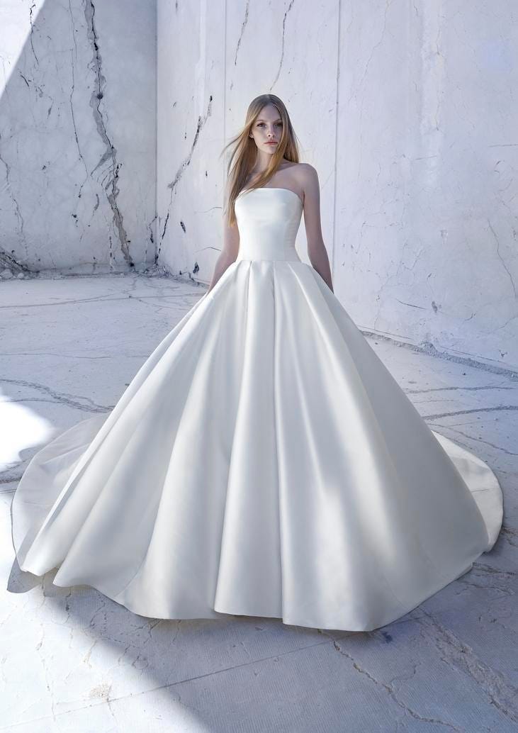 Donna che indossa un abito da sposa semplice senza spalline con una gonna lunga e voluminosa