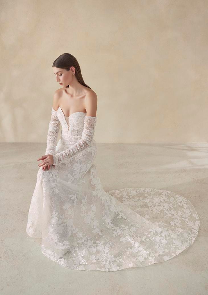 Vestito da Sposa in Pizzo Modella inginocchiata che indossa un abito da sposa in pizzo con scollo a cuore e strascico