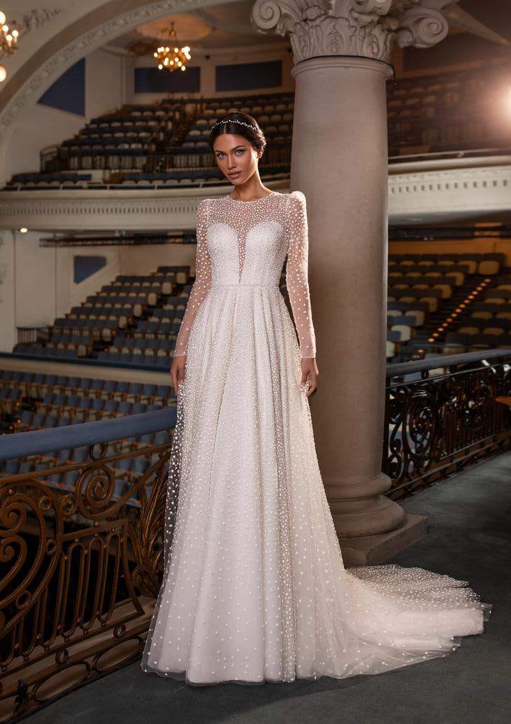 Une jeune femme en robe de mari&eacute;e trap&egrave;ze avec un joli d&eacute;collet&eacute; c&oelig;ur rehauss&eacute; de tulle transparent et de d&eacute;licates perles