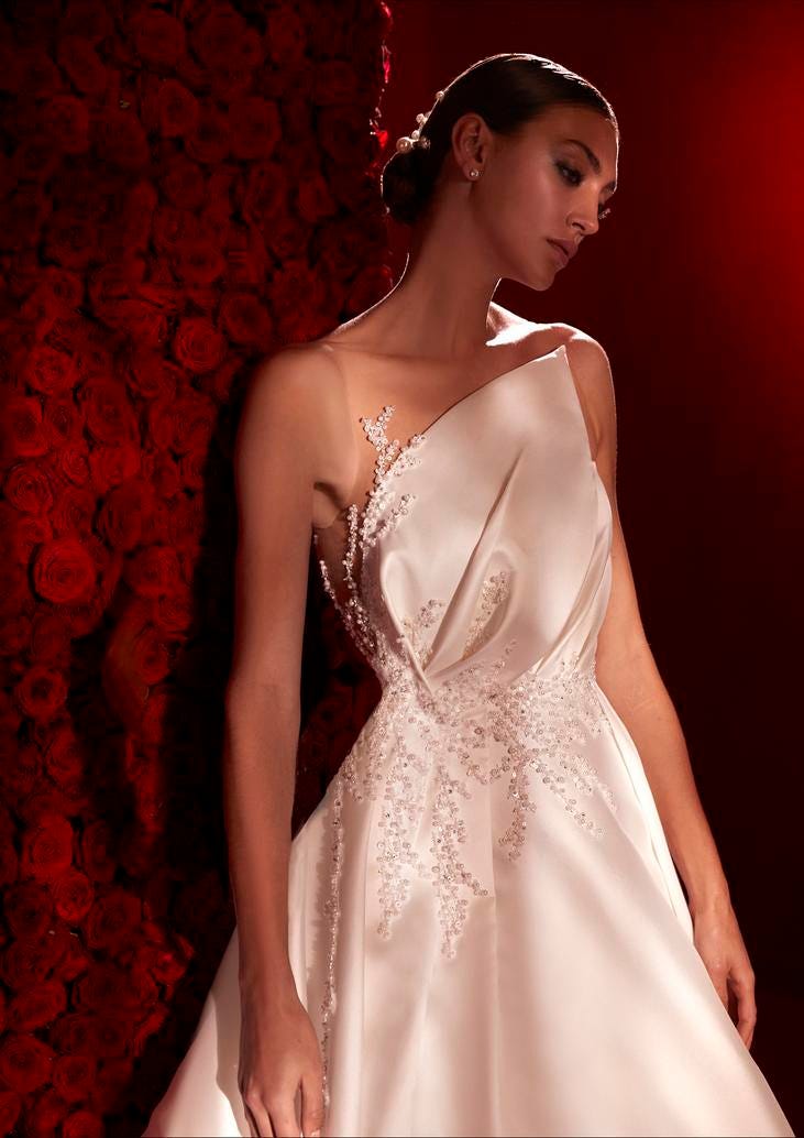 Abito da Sposa Decorato Modella in primo piano che indossa un vestito da sposa con scollatura particolare e decorazioni sul punto vita.