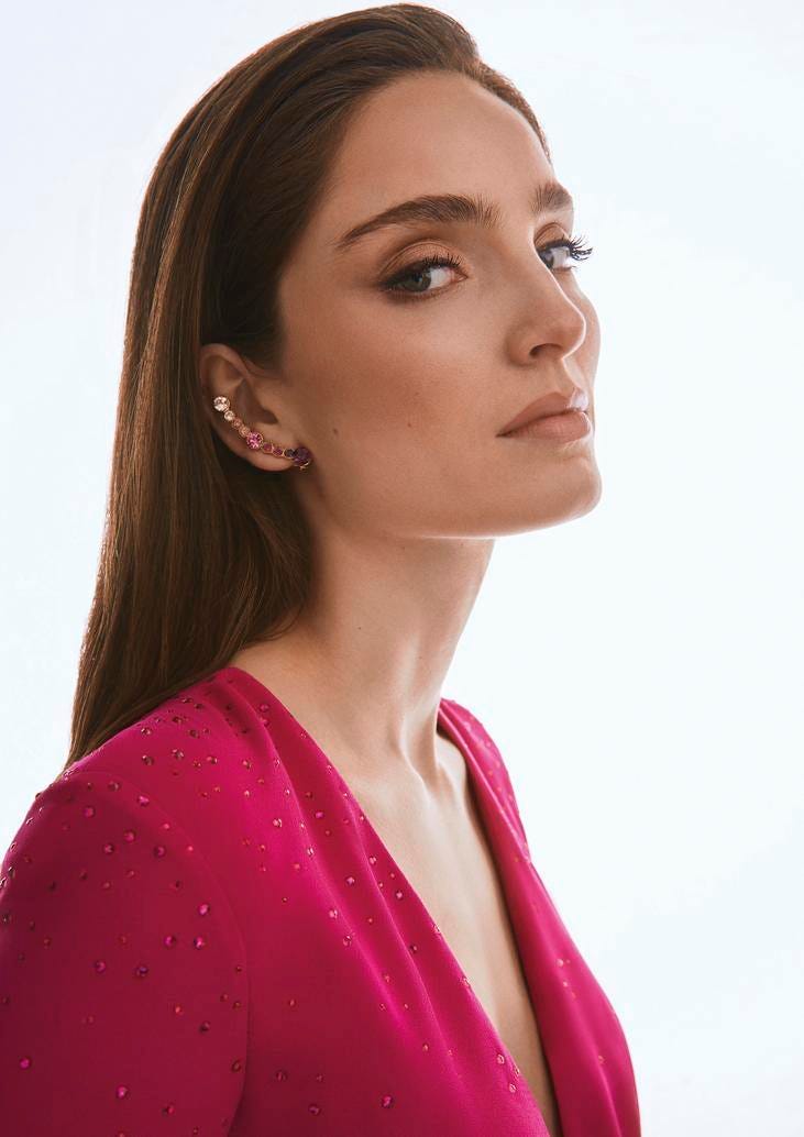 Convidada usando um brinco ao longo de toda a orelha conjugado com um vestido rosa de decote em bico