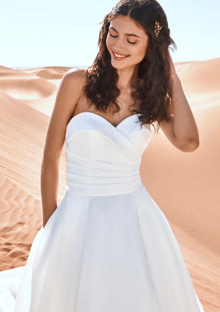 Noiva com cabelos soltos com gancho e um vestido simples de decote coração 