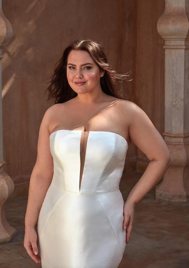 Curvy woman in a Mikado mermaid wedding dress with a sensual button seam and plunging V neckline