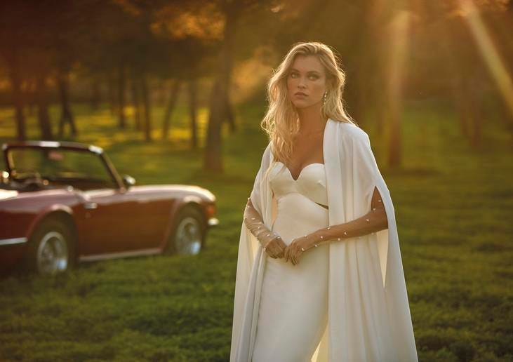 Retro &uuml;st&uuml; a&ccedil;ık arabanın yanında duran dalgalı gelinlik sa&ccedil; modeline sahip gelin