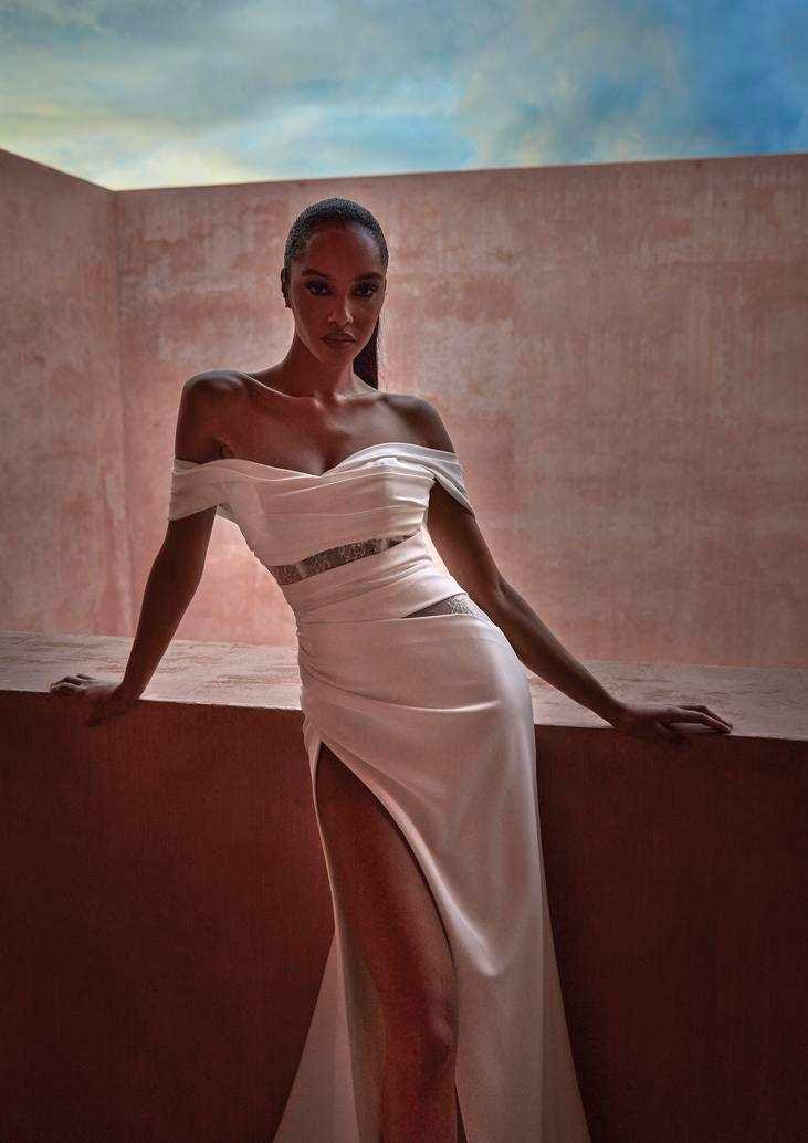 Mujer vestida de novia con un vestido ajustado con abertura lateral dejando la pierna expuesta