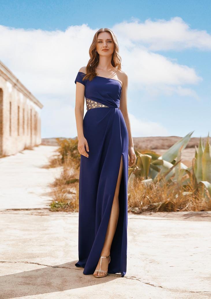 Donna che indossa un abito da invitata a un matrimonio lungo blu scuro con uno spacco laterale