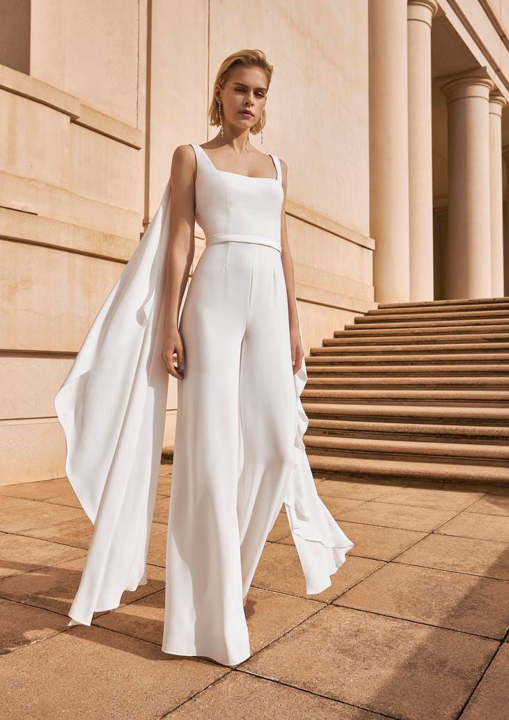 Combinaison blanche pour mariage civil Une femme élégante en combinaison blanche et cape pour un mariage civil. Un look luxueux et sophistiqué.