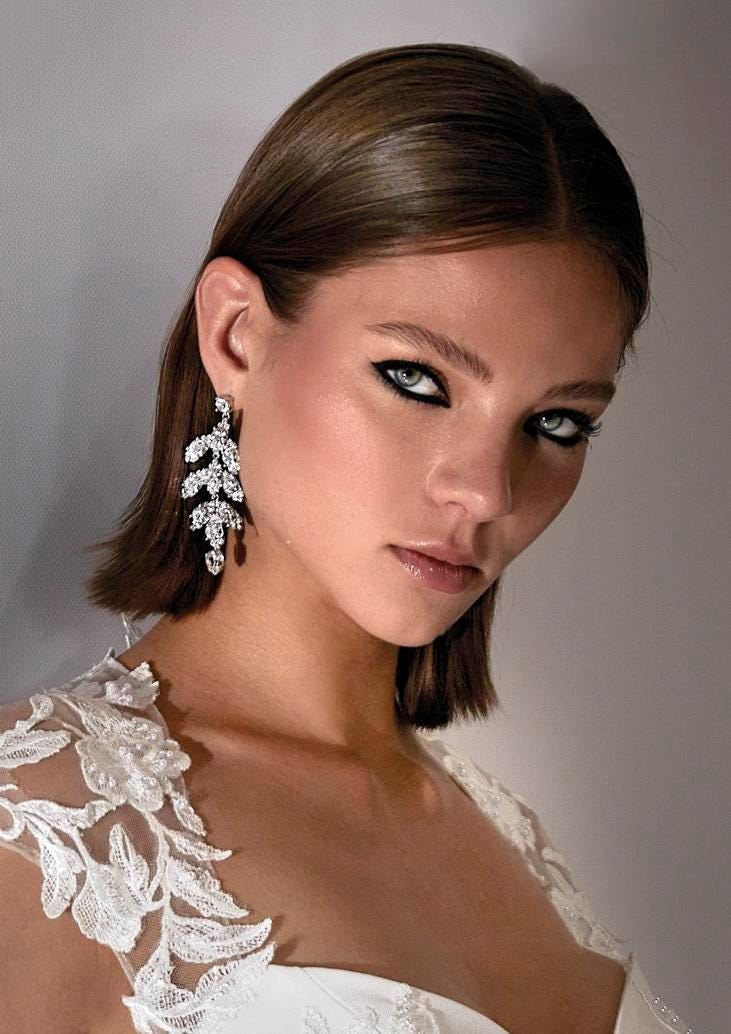  Mujer luciendo unos pendientes de novia colgantes color plata brillantes 