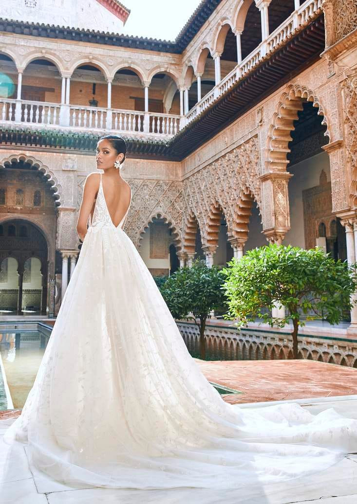 Une mariée dans une robe de mariée princesse ornée d'un décolleté au dos. La robe est parée d'un motif en dentelle charmant