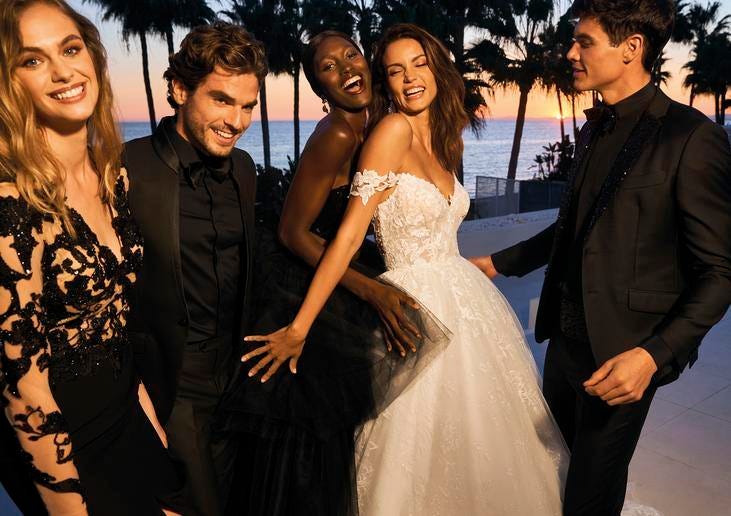 Wybór odpowiedniej kwoty na prezent dla pary młodej Panna młoda ubrana w białą suknię ślubną oraz pan młody i przyjaciele ubrani na czarno tańczący podczas imprezy weselnej