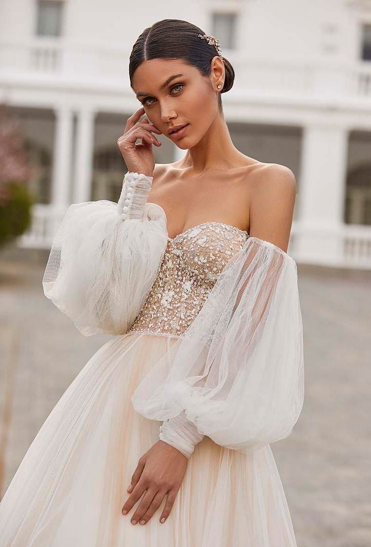 Une mari&eacute;e ravissante dans une robe de mari&eacute;e bustier perl&eacute;e dot&eacute;e de manches bouffantes amovibles et d'une jupe en tulle.