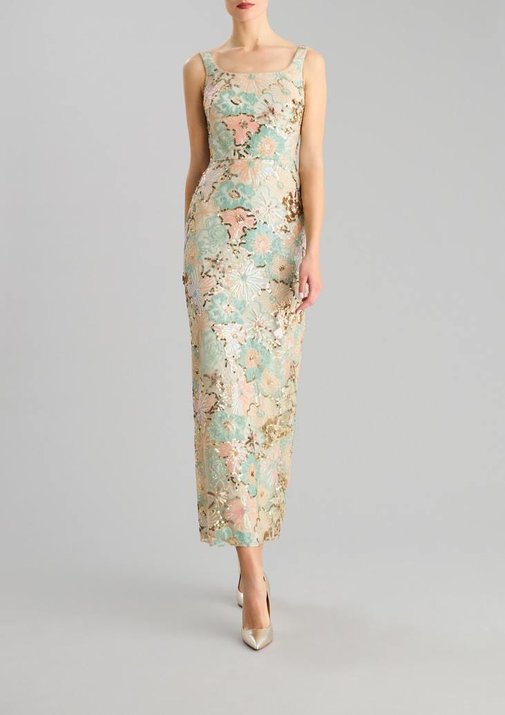 Donna che indossa un abito da cerimonia elegante sbracciato a tubino con dettagli e decorazioni di paillettes. 