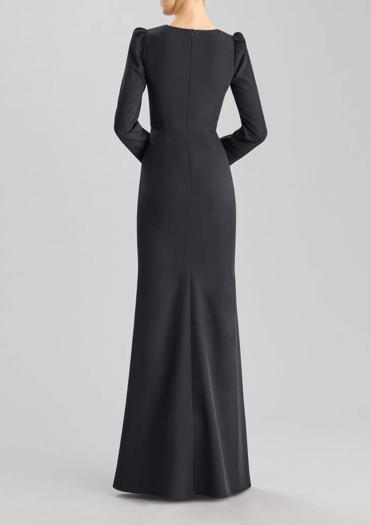 Mujer de espaldas luciendo un vestido de testigo de boda de manga larga negro y largo con corte recto