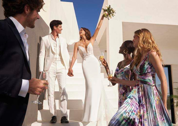 Man and woman walking down stairs with woman's hand up holding a bouquet of flowers