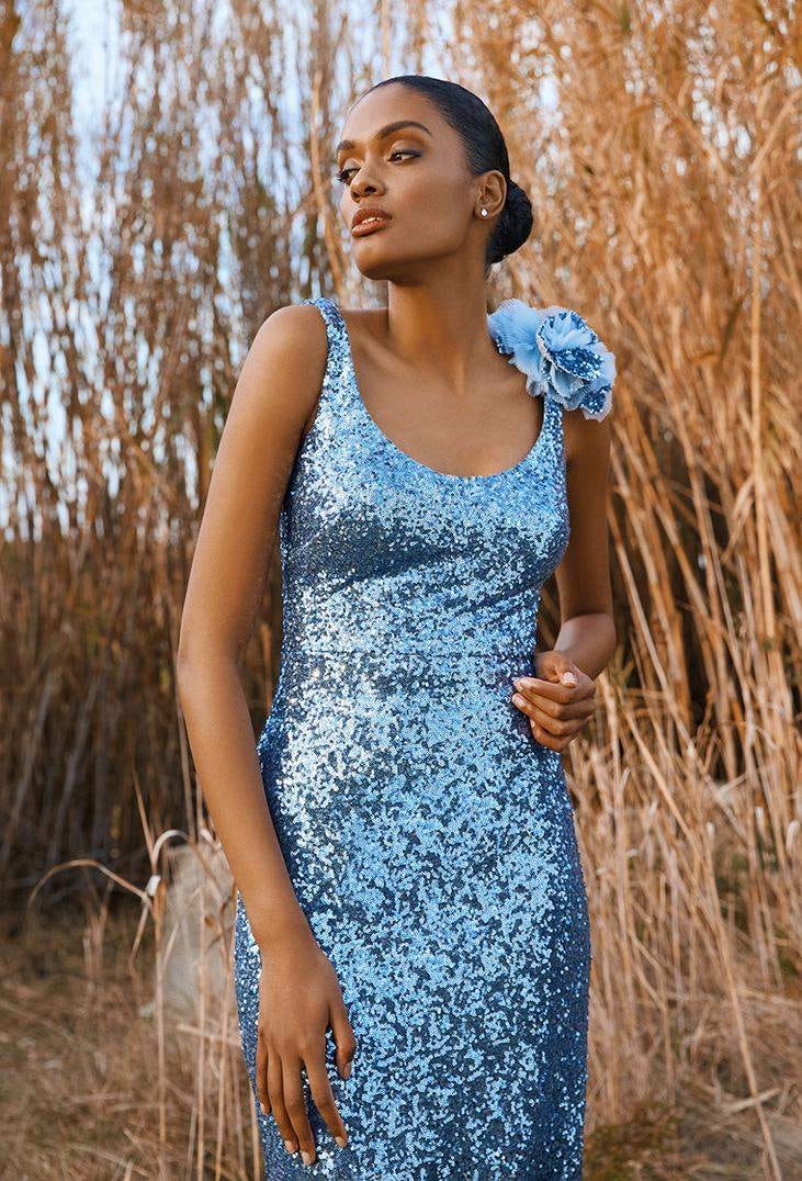 Une demoiselle d'honneur porte une robe longue bleue &agrave; sequins &agrave; bretelles, l'une d'elles est habill&eacute;e d'une fleur bleue 3D.