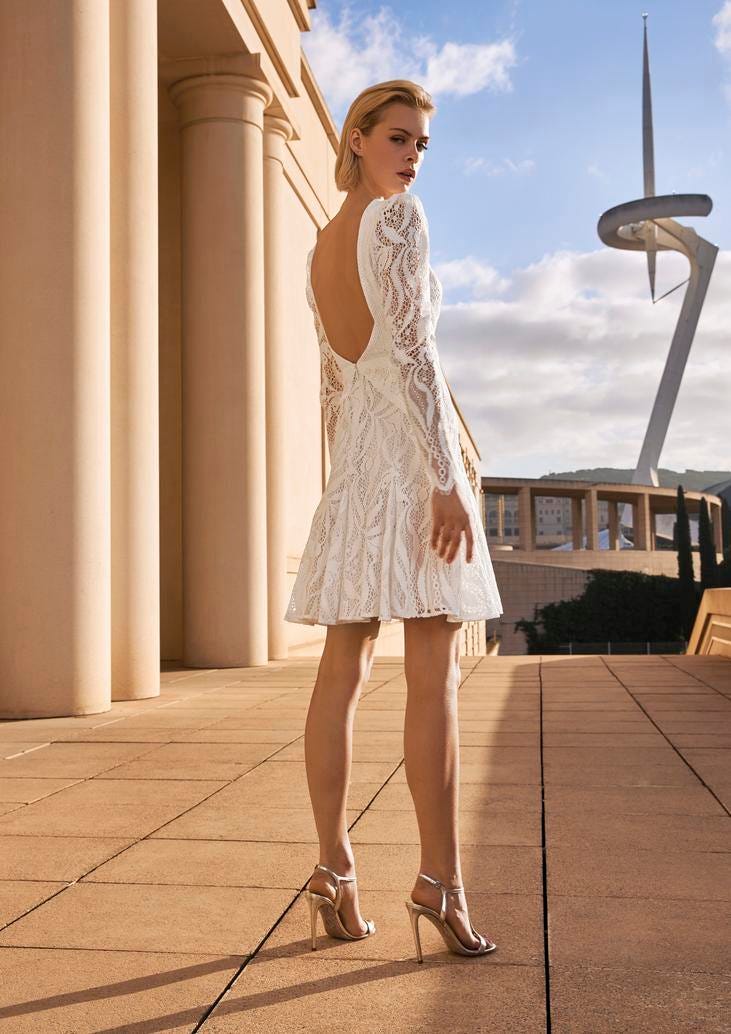 A&ccedil;ık alanda uzun kollu dantelli kısa gelinlik modeli giyen kısa sa&ccedil;lı kadın