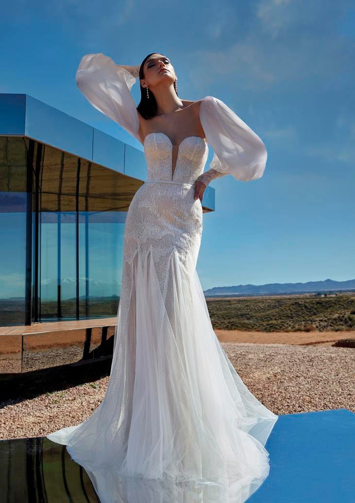 Donna all'esterno con vestito da sposa a sirena glitterato, scollo a V e maniche a sbuffo