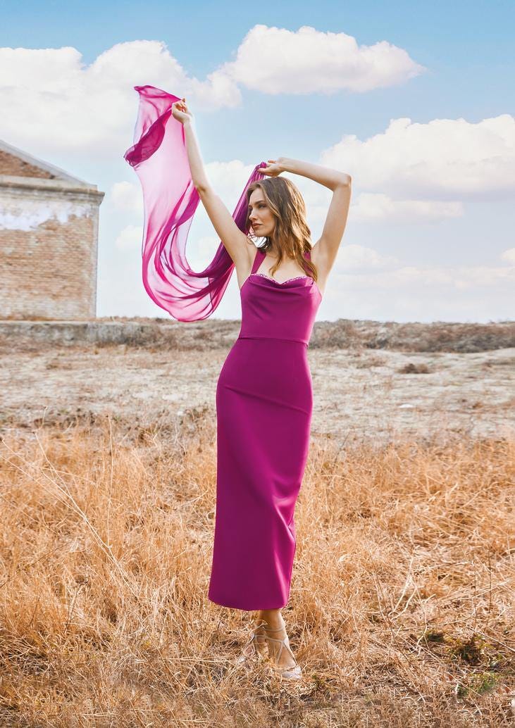 Modella che indossa un colorato abito da cerimonia elegante con spalline spesse e una stola leggera